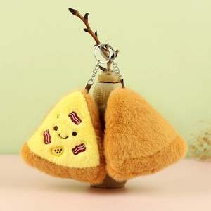 Detail view of cute plush pizza keychains with embroidered faces on tree branches