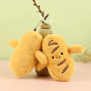Close-up of cute plush bread keychains with smiling faces hanging on a branch