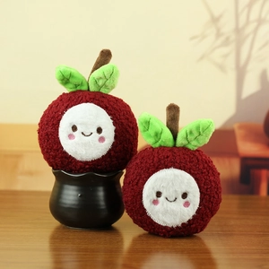Cute lychee plush doll set with soft red texture and green leaves on wooden table