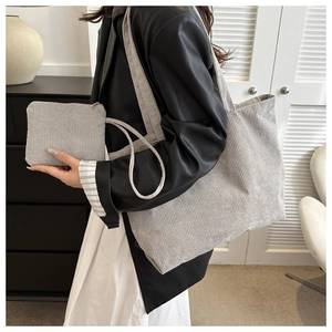 Detailed view of grey corduroy tote bag and matching pouch showing fabric texture