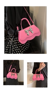 Détail d'un sac bandoulière rose à bords ondulés avec nœud en métal argenté et chaîne