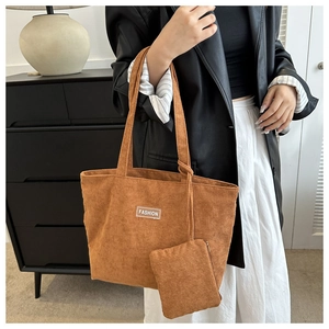 Detail showing brown corduroy tote set with smaller pouch and fashion label on a model