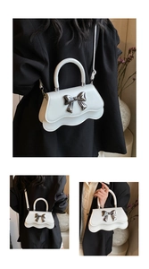 Détail du sac à main blanc à rabat ondulé avec nœud en métal argenté et bandoulière