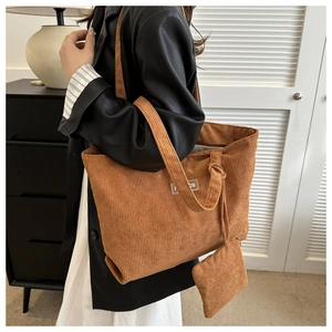 Close-up of caramel corduroy tote bag texture with fashion label and small pouch