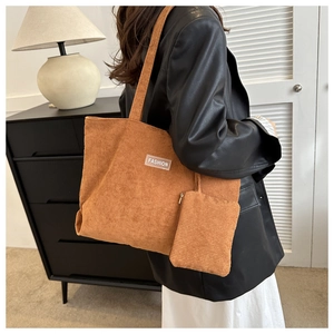 Detailed close-up of caramel corduroy tote bag texture and fashion label with small pouch