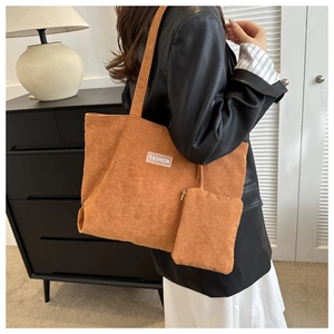 Detail of caramel corduroy tote bag with small matching pouch and fashion label