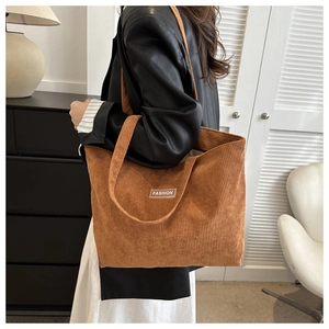 Detailed view of brown corduroy tote bag with vertical stripes and FASHION label