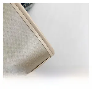 Detailed view of beige textured fabric and precise stitching on large floral tote bag