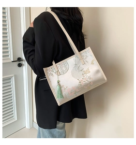 Detail of Chinese style tote bag with floral embroidery and light green tassel