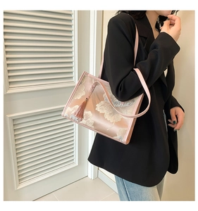 Detail of floral embroidery on a light pink tote bag with stylish silk tassel charm