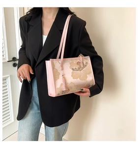Detail of light pink floral tote bag featuring elegant embroidery and fringe tassel charm
