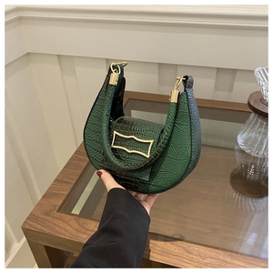 Detailed shot of crocodile embossed dark green hobo bag with gold geometric buckle