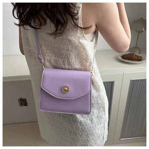 Petit sac carré lavande porté par un mannequin dans un intérieur élégant et épuré