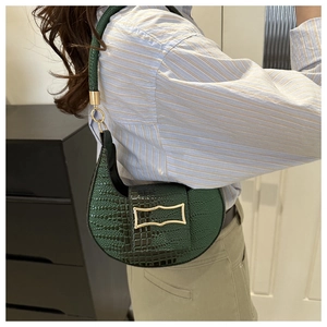 Detail of emerald green crescent bag with crocodile texture and gold metal buckle