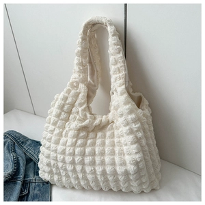 Detail of creamy white popcorn texture tote bag with pleated fabric and elastic strap