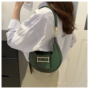 Detail of dark green crescent shoulder bag with crocodile pattern and golden buckle