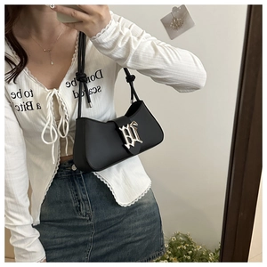 Detail view of black leather underarm bag with silver Gothic letter buckle and thin strap