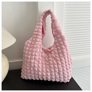 Close-up of pink bubble texture fabric on a soft knit shoulder bag in home setting