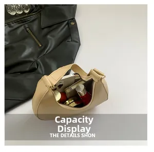 Detailed interior capacity showing daily essentials in a beige moon hobo shoulder bag