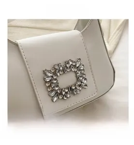 Détail macro d'un sac à bandoulière en cuir blanc avec boucle étincelante en strass chic