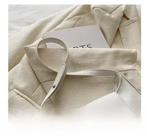 Détail du sac baguette en cuir blanc avec une grande boucle carrée en cristal brillant