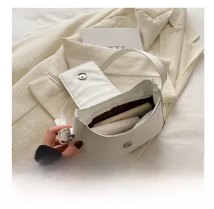 Vue intérieure montrant la capacité d'un sac sous le bras en cuir blanc à rabat