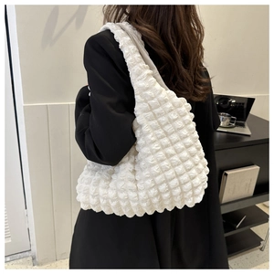 Detailed view of white bubble texture fabric on a large capacity shoulder tote bag