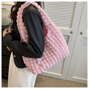 Gros plan détaillé sur le tissu gaufré rose d'un sac à bandoulière plissé élégant