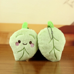 Detailed close-up of cute green leaf plush pendant with smiling face and bead chain