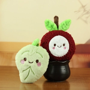Detailed close-up of cute plush lychee toys with embroidered faces on a wooden table