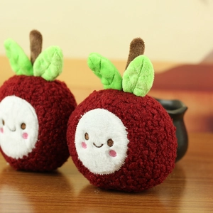 Close-up of cute plush mangosteen toy with a smiley face on a warm wooden background