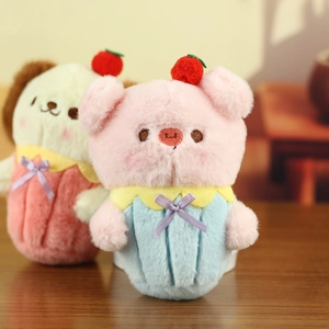 Detail von Plüsch-Schwein- und Welpenanhängern mit Kirsche und gestreifter Cupcake-Basis