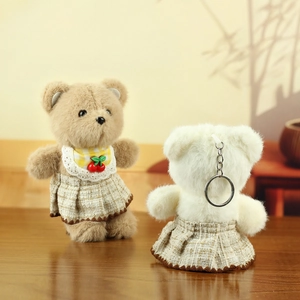 Detail of plush bear keychains in retro plaid skirts with lace bib and metal ring