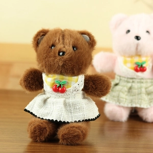 Close-up of cute plush bears in lattice lace dresses with cherry details on wood floor