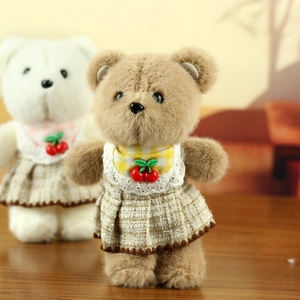 Close-up of small plush teddy bears wearing British style checkered cherry dresses