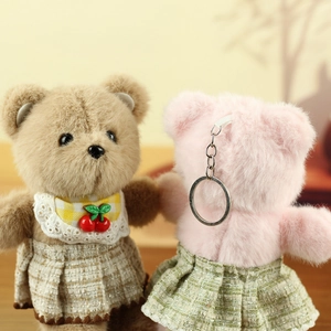 Detail of plush teddy bear charms with checkered bib and metal keychain attachment