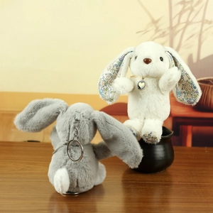 Detail of plush long-eared rabbit pendants in white and grey with floral ear lining