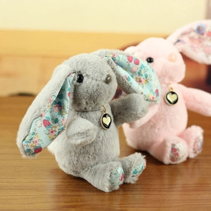 Close-up of plush long-eared rabbits with strawberry floral prints and heart necklaces