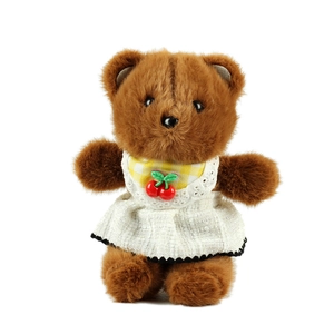 Brown teddy bear plush toy wearing cherry lace dress on white background