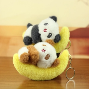 Cute panda plushies on crescent moons with metal keychains on a wooden desk