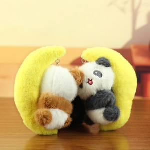 Close-up of plush panda and hamster characters inside yellow moon charms on wooden desk