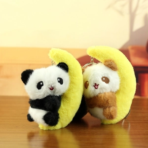 Detail of plush panda on yellow moon charms with metal keychains on wood background