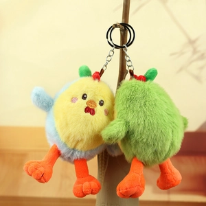 Plush chick eggshell keychain set in yellow and blue hanging on a wooden branch