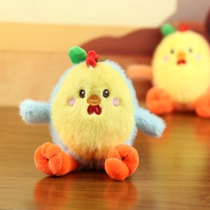 Close-up of cute chick plush keychain with detailed embroidery on a wooden surface