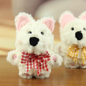 Dettaglio del ciondolo peluche Westie con fiocco a quadri rossi su un tavolo di legno