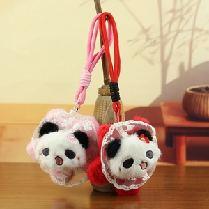 Süßer Panda-Plüsch-Schlüsselanhänger mit Spitzenkragen und Blume auf Holzhintergrund