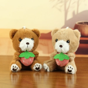 Detailopname van teddybeer bedeltjes met aardbeiendetail en ophangriempjes