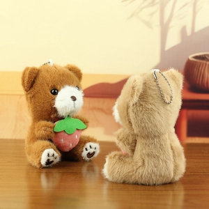 Detail van mini pluche teddyberen met aardbeien en zilveren metalen kogelkettingen