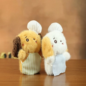 Close-up of cute plush dog keychains in chef outfits with striped aprons and hats
