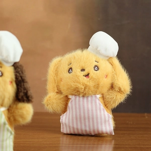 Close-up of cute plush dog keychain wearing a white chef hat and pink striped apron
